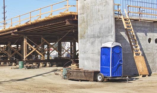 a row of modern portable toilets at a busy job site, designed for easy use and maintenance